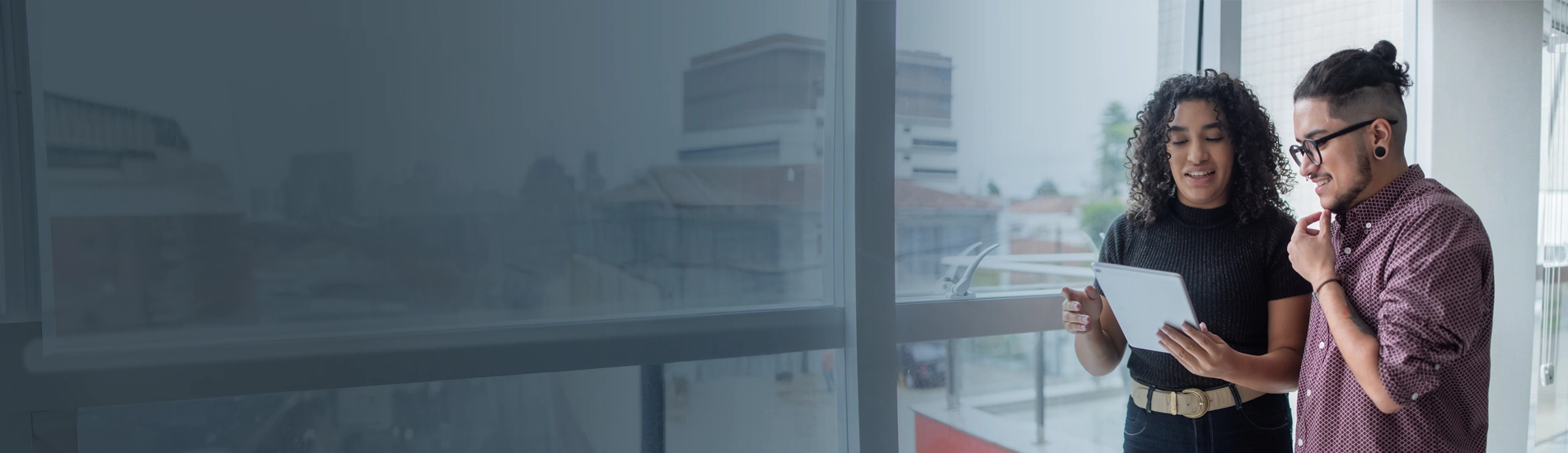 A woman and a man chatting while reading a tablet
