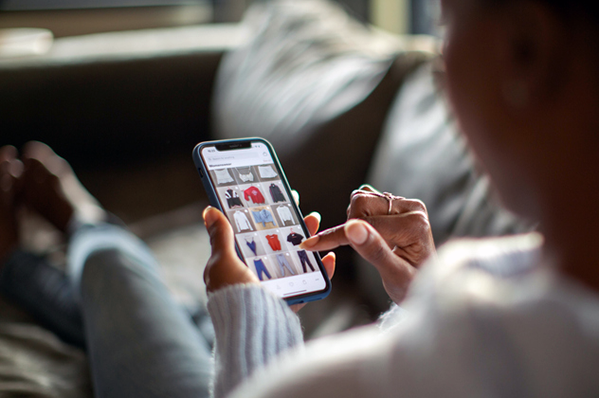 woman looking at clothes for sale on her phone