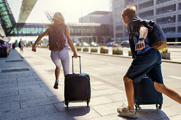 Couple running with luggage at an airport