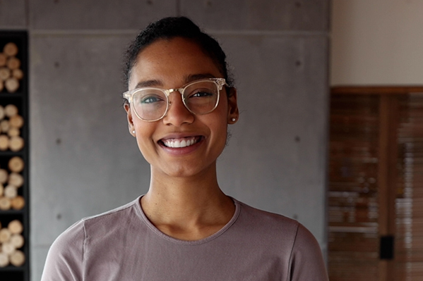 young confident woman wearing glasses looking directly at the camera and smiling