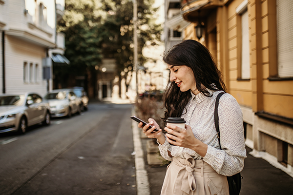 woman looking at her cellphone on street