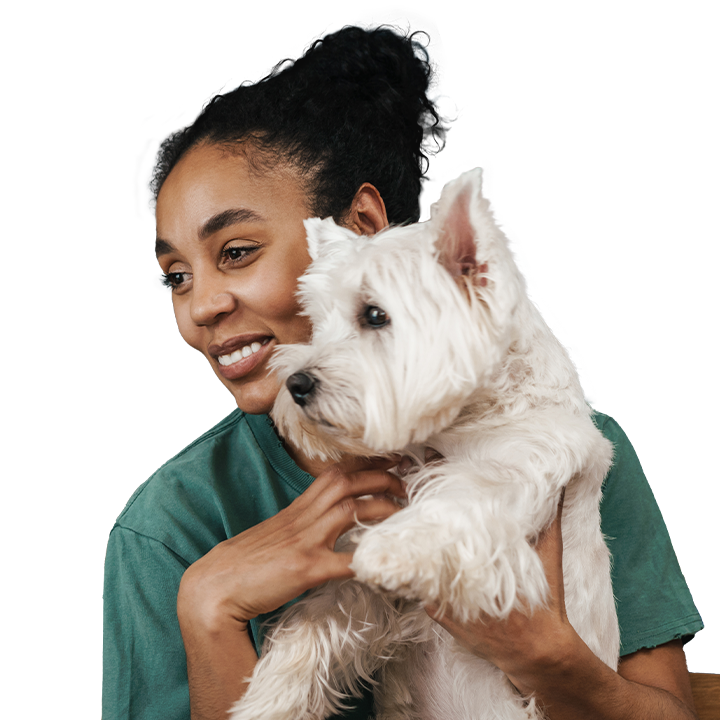 woman smiling while holding a dog