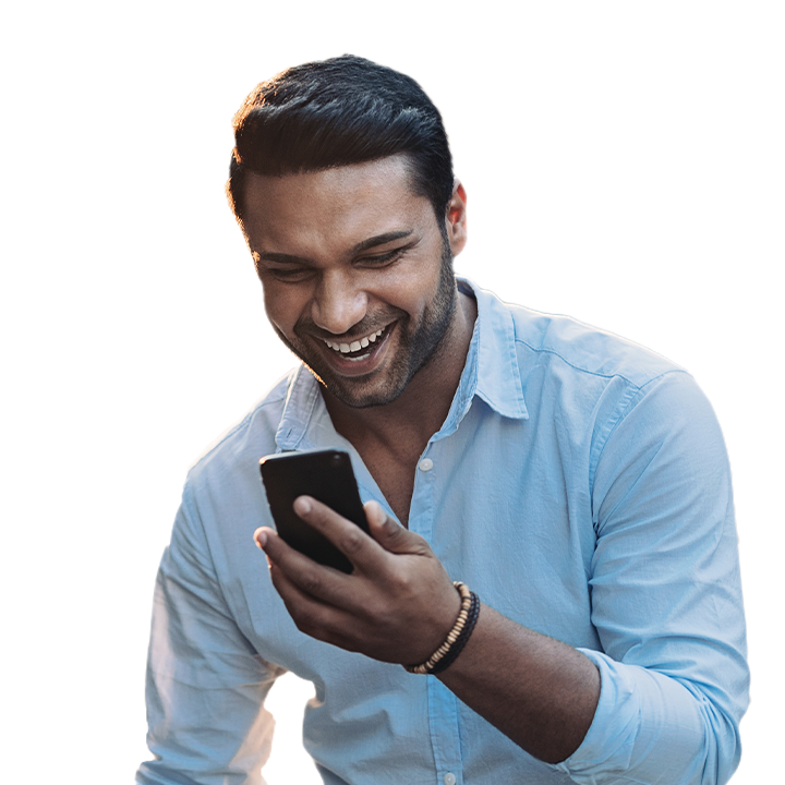 man smiling while staring at his phone screen