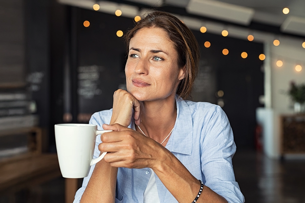 woman in kitchen with cup of espresso